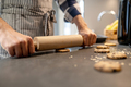 Hands of man pressing rolling pin on raw cookie - PhotoDune Item for Sale