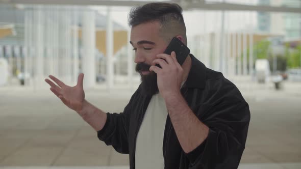 Emotional Young Man Talking on Phone Outdoor