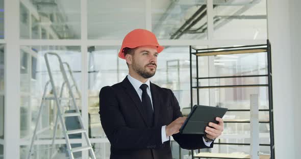 Bearded Manager of Building Company in Hardhat which Inspecting New Office Building