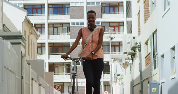 Woman walking with bicycle in city street