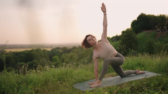 Woman Practises Yoga at Sunrise in Pine Forest