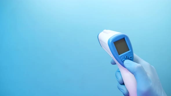 Hand Holding Infrared Thermometer To Measuring Temperature