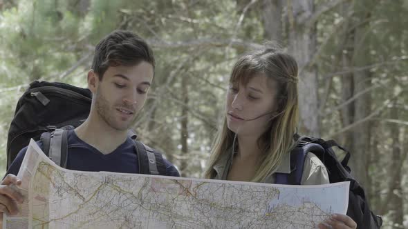 Hikers looking at map in woods