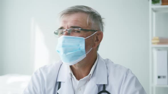 Elderly Grayhaired Doctor in Protective Mask Closeup Portrait of Male Therapist Wearing Glasses