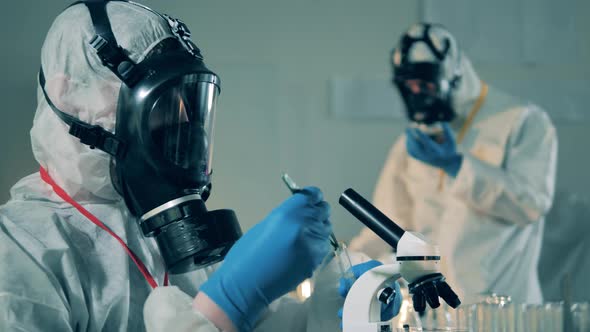 A Man in Protective Suit Works with Test Tubes in Laboratory During Pandemic.