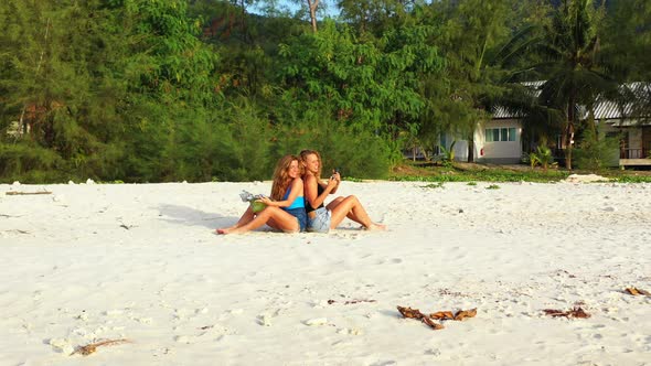 Sexy smiling ladies relaxing enjoying life on beach on paradise white sand and blue 4K background