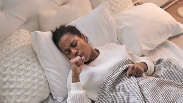 Top View of Sick Young African Girl Coughing While Sleeping in Bed
