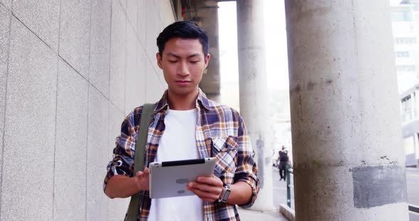 A man walking and using a tablet computer