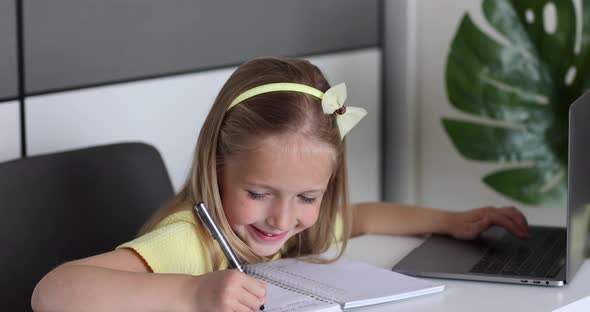 Caucasian Little Girl School Pupil Studying Online From Home Watching Web Class Lesson or Listening