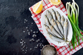 Fresh sea small fish on a plate on a dark background - PhotoDune Item for Sale