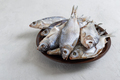 Dried salty river fish in a bowl on a light concrete background. - PhotoDune Item for Sale