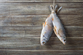 Salted and dried fish fish hanging on a string on a wooden background - PhotoDune Item for Sale