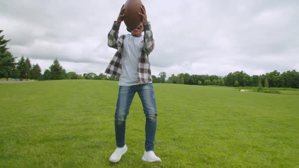 Excited School Age Black Boy Celebrating Touchdown on Field