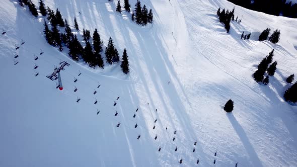 Aerial view of People Skiing and snowboarding on hill, Ski Resort. Drone flies over Skiers Skiing do