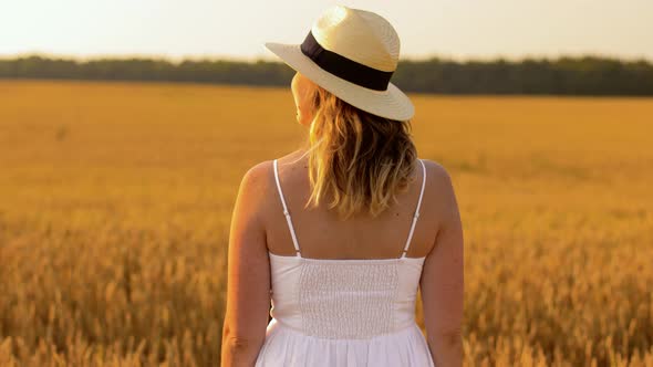 Woman in Straw Hat on Cereal Field in Summer