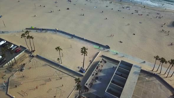 Venice beach California Drone shoting forward  panning up on beach  front over basketball courts wit