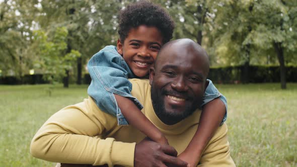 Portrait of Smiling Afro-American Son and Dad in Park