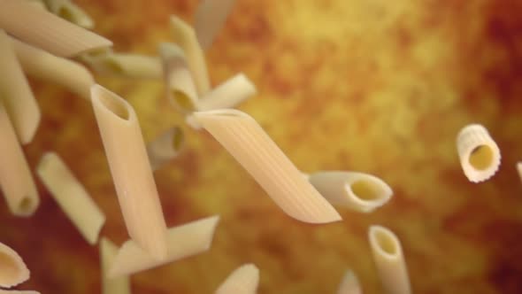 Close-up of Dry Raw Pasta Penne Flying Diagonally on a Yellow Ochre Background