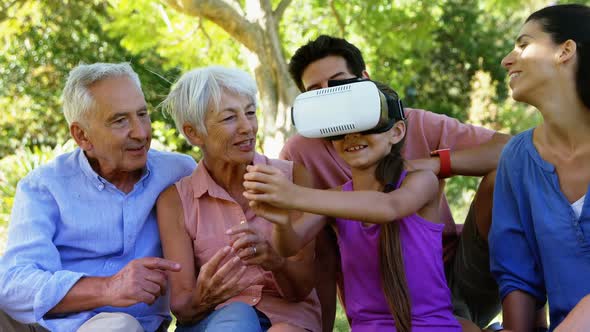 Girl using vr headset while sitting with her family 4k