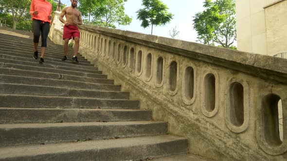 A couple running on stairs in a city as a workout