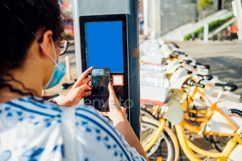 �� Woman paying wireless for renting bike sharing