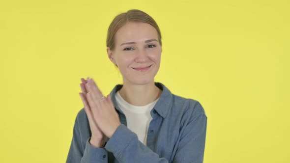 Young Woman Clapping Applauding on Yellow Background