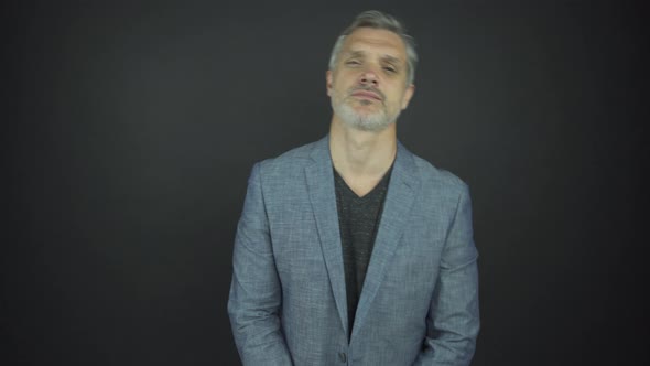 Man Model with Grey Hair and Beard Poses with Serious Face