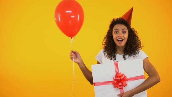 Happy Teenager Holding Balloon and Huge Giftbox, Celebrating Birthday, Greetings