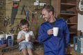 Father and son working in home garage having coffee break - PhotoDune Item for Sale