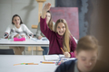 Happy teenage girl raising hand in class - PhotoDune Item for Sale