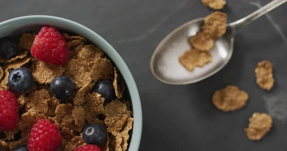 Video of cereals and fruit in ceramic bowl on stone kitchen worktop