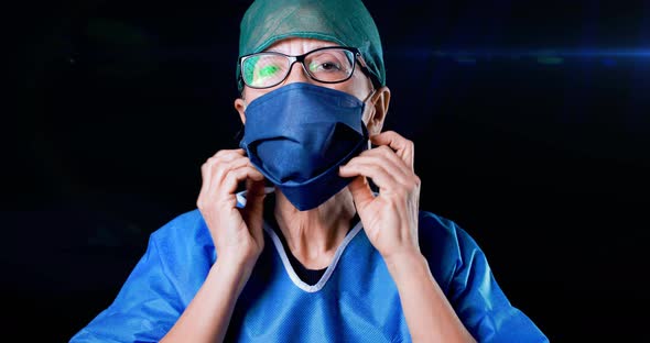 Doctor Woman Demonstrates how to Put on the Mask. alt