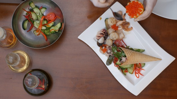 Decorating fresh vegetables salad with caviar