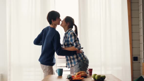 Loving Young People Husband and Wife Are Dancing in Kitchen and Kissing Laughing and Smiling