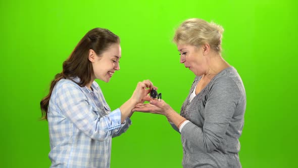 Girl Gives the Keys To Her Mom. Green Screen. Side View