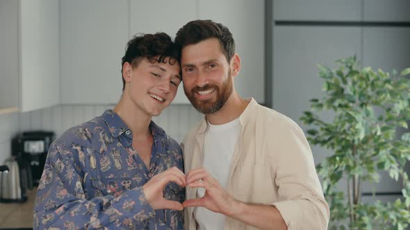 Portrait of the Two Lgbt Men Standing in Their New Apartment and Showing Heart Shape Using Their