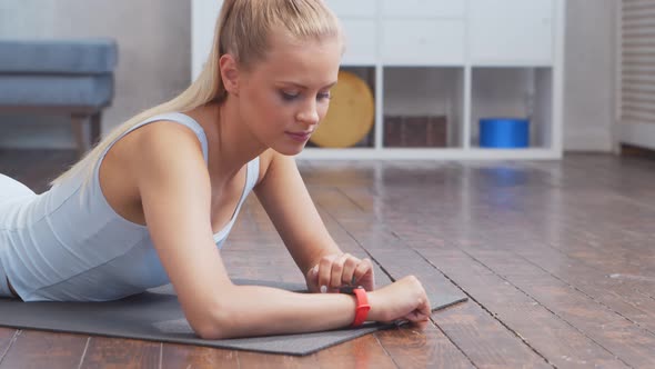 Young and sporty girl in sportswear is doing exercises at home.