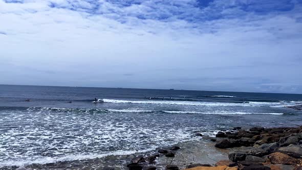 Quick Pan view of surfers and swimmers at Moffat Beach, Sunshine Coast Queensland Aus