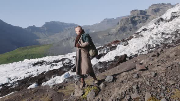 Travelling Man Standing On Rocky Hillside By Glacier