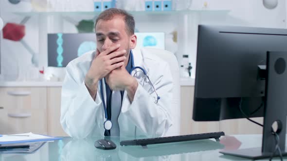 Tired and Exhausted Physician in His Office Working