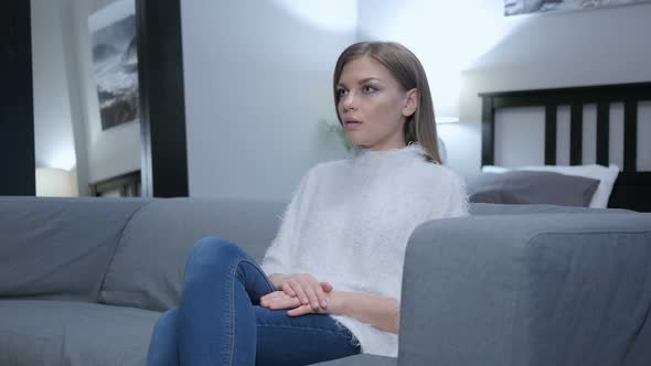 Woman Sitting on Couch in Bedroom