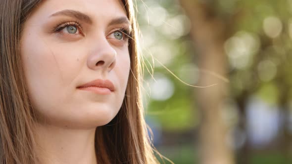 Girl Opening Her Beautiful Blue Eyes Wind Blowing on Brunette Hair