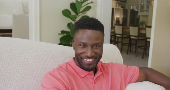 Portrait of smiling african american man looking at camera in living room