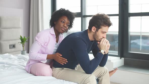 Relationship Problems. Frustrated Young Mixed Raced Couple Sitting in Bed