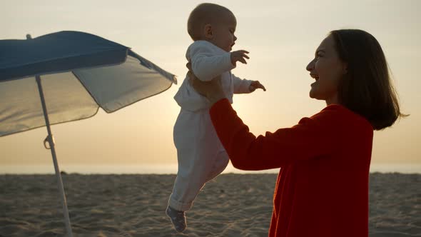 Mom on the Beach with Her Newborn Baby