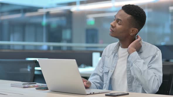 African Man with Laptop having Neck Pain