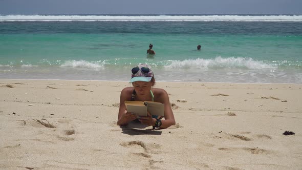 Girl on the Beach Reading a Book