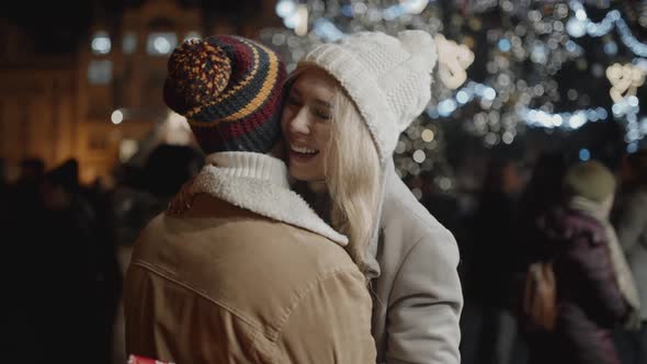 Portrait of Beautiful Girl Meeting Friend in a Middle of Christmas Fare