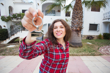 – Woman with keys standing outside new home.