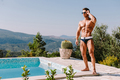 Handsome muscular man relaxing in swimming pool outdoors on summer day - PhotoDune Item for Sale